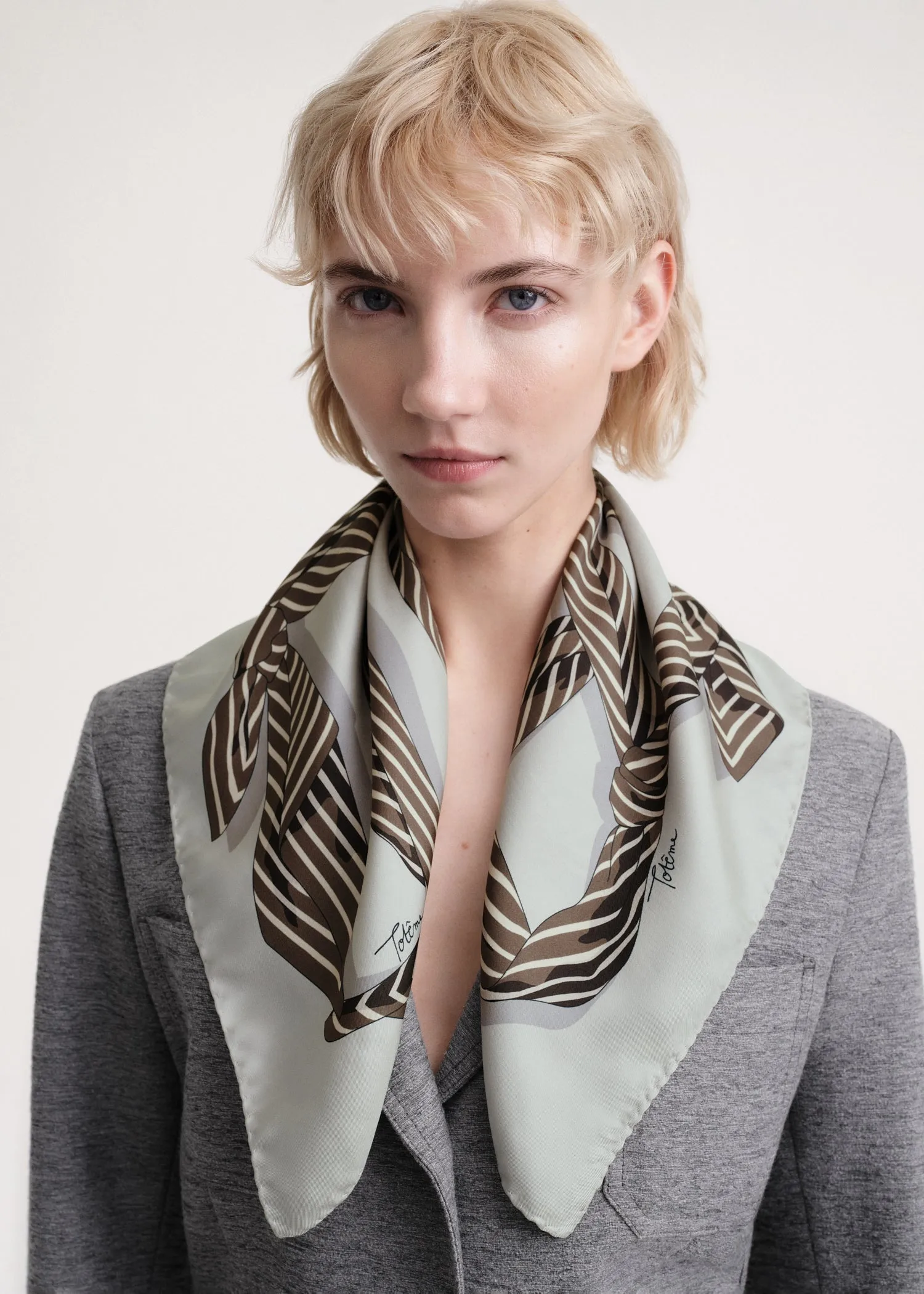 Knotted monogram silk scarf silver grey sold by Toteme