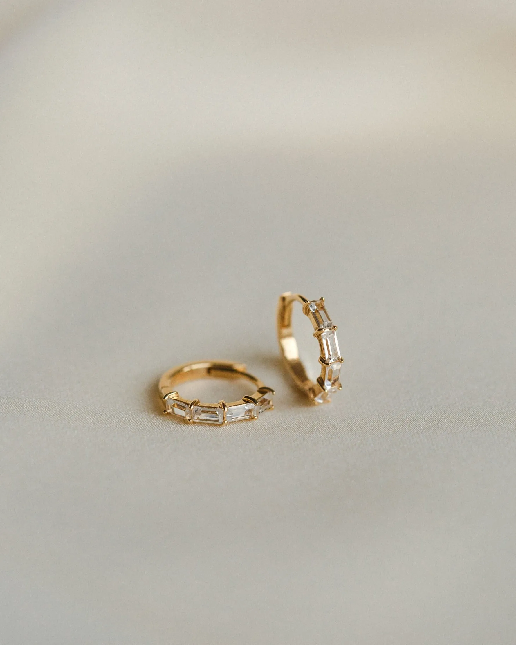 Nouveau White Sapphire Huggie Hoops sold by GLDN