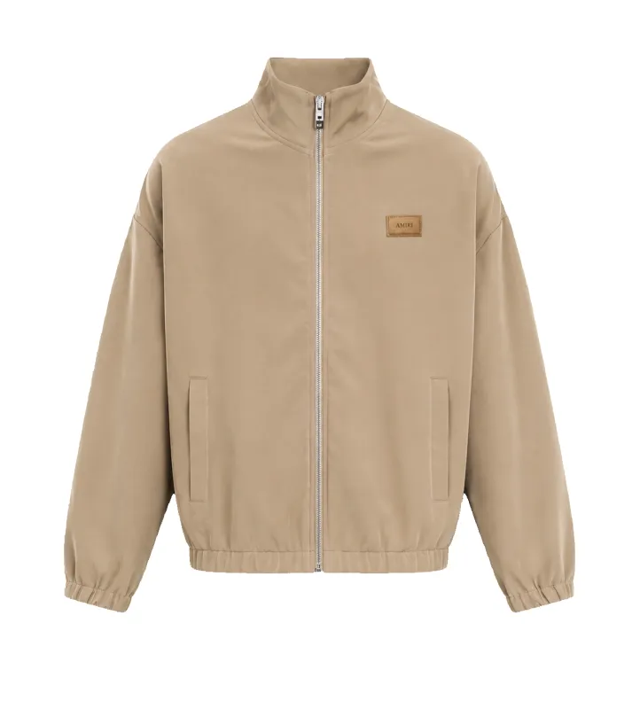Logo Patch Bomber Jacket in Dark Sand made by AMIRI