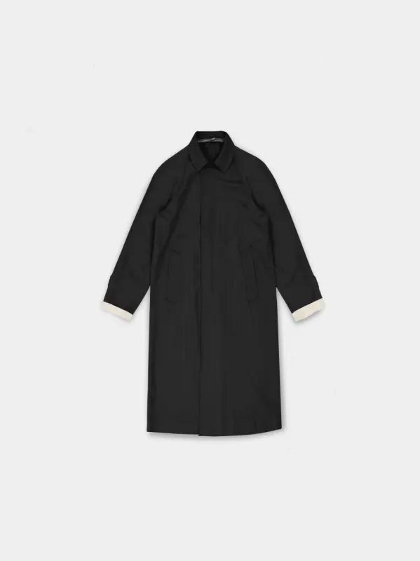 The “Lien” Virgin Wool Coat in matte black sold by vuja dè