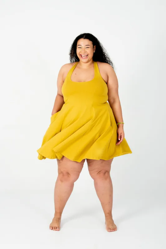 Asri Cross Back Mini Dress In Mustard Seed sold by Manners London