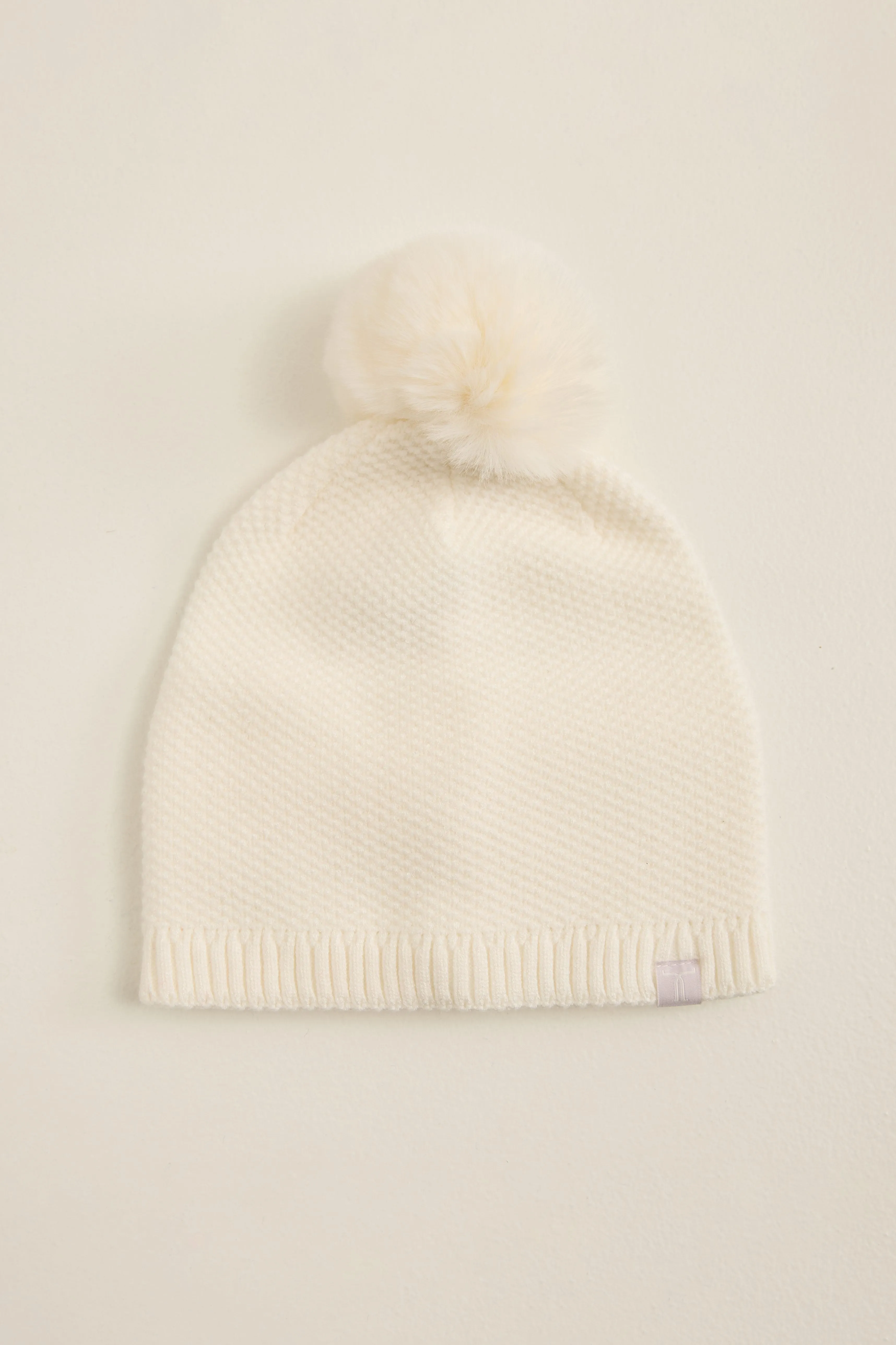 Hat with fake fur pompom sold by Tristan Style