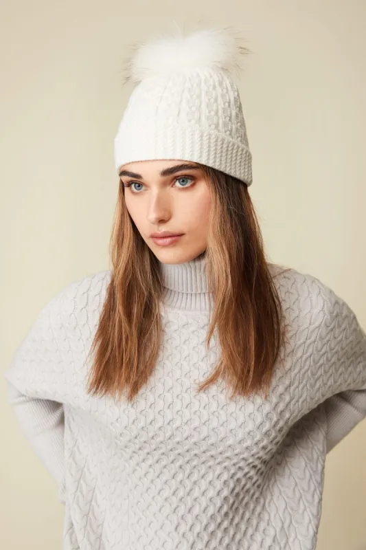 Cable hat with fur pompom sold by Tristan Style