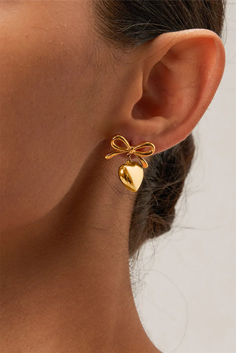 Gold Heart and Bow Studded Earrings sold by Threaded Pear