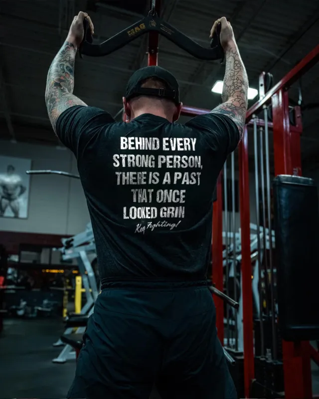 Behind Every Strong Person There Is A Past That Once Looked Grin Printed Men's T-shirt sold by Polyalien