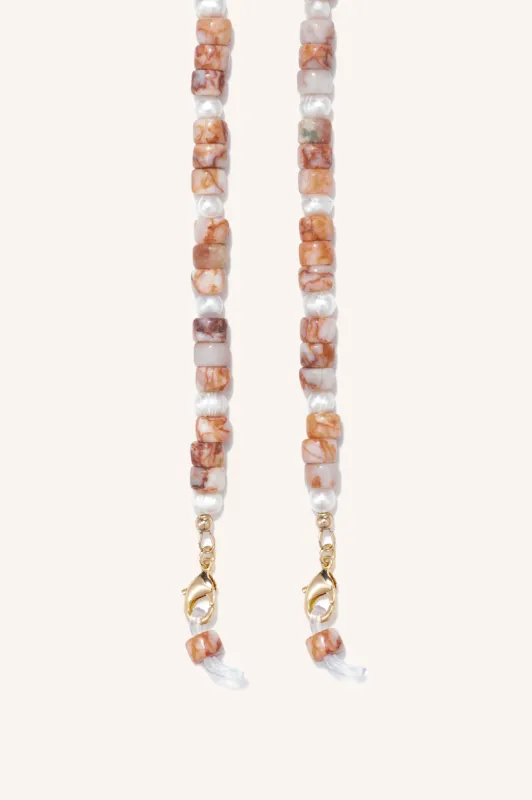 gem + pearl mask/sunny chain sold by DONNI.
