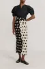 Black & white pencil skirt with circular pockets and button details sold by DESTREE