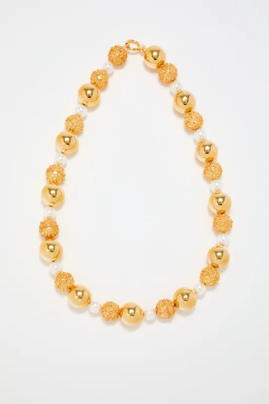 Gold sculptural necklace with white pearl detail sold by DESTREE
