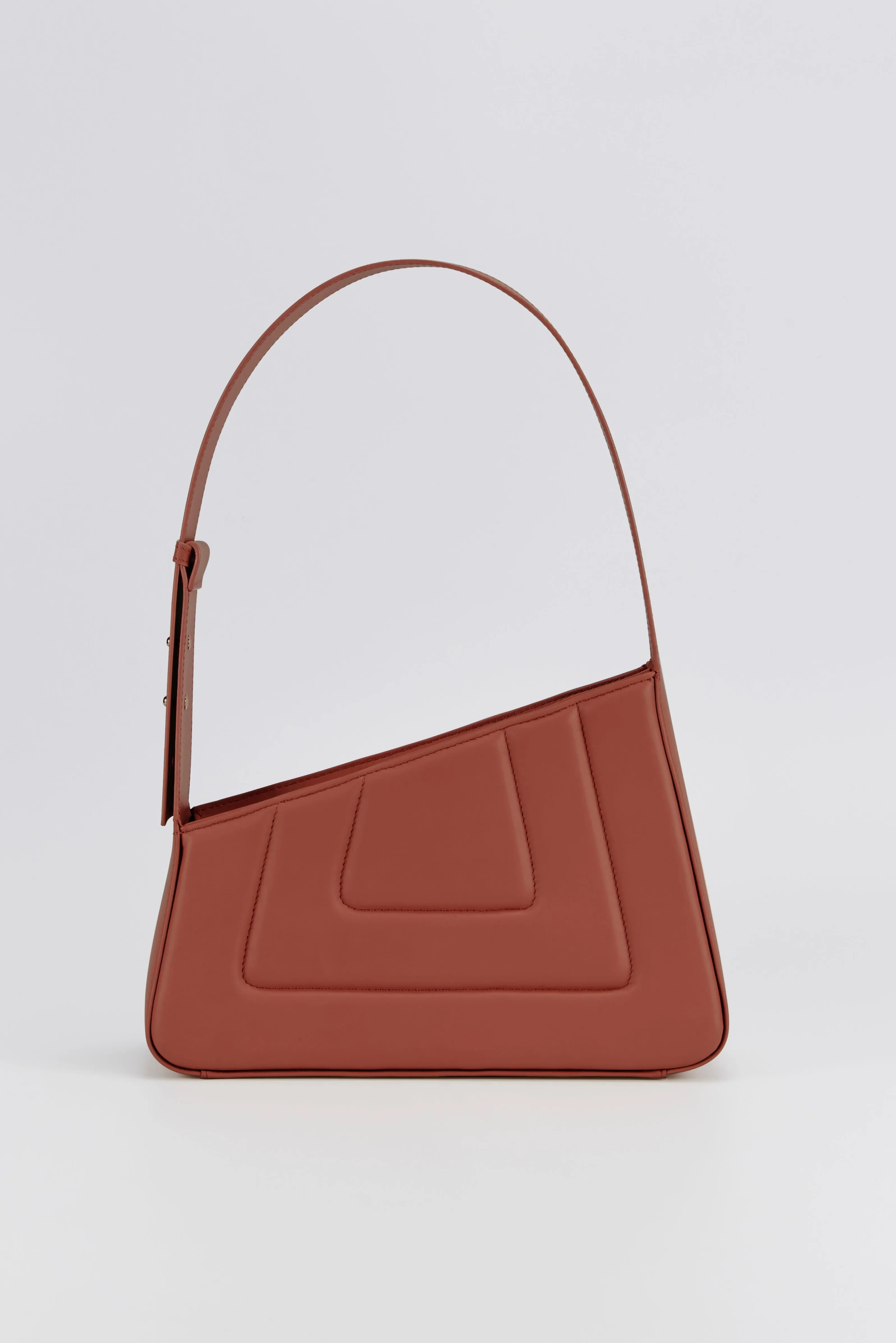 Rust asymmetric leather quilted bag sold by DESTREE