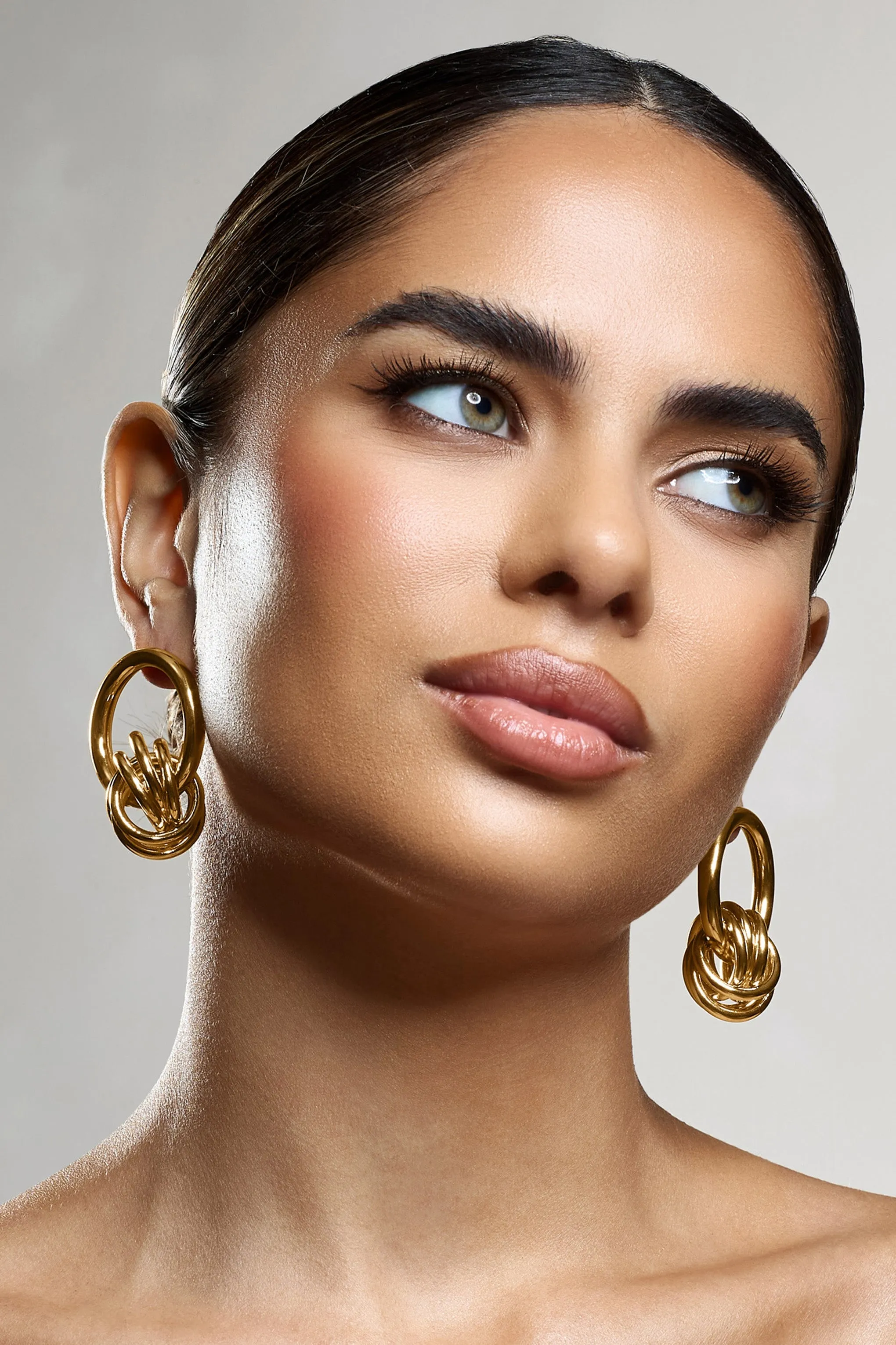 Tied Down | Gold Knot Dangle Earrings sold by Club L London product image thumbnail 2