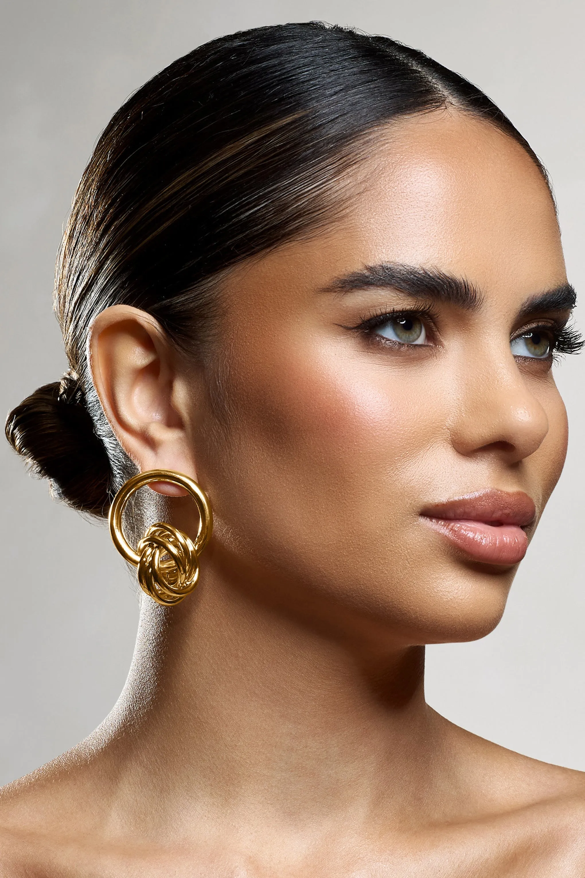 Tied Down | Gold Knot Dangle Earrings sold by Club L London