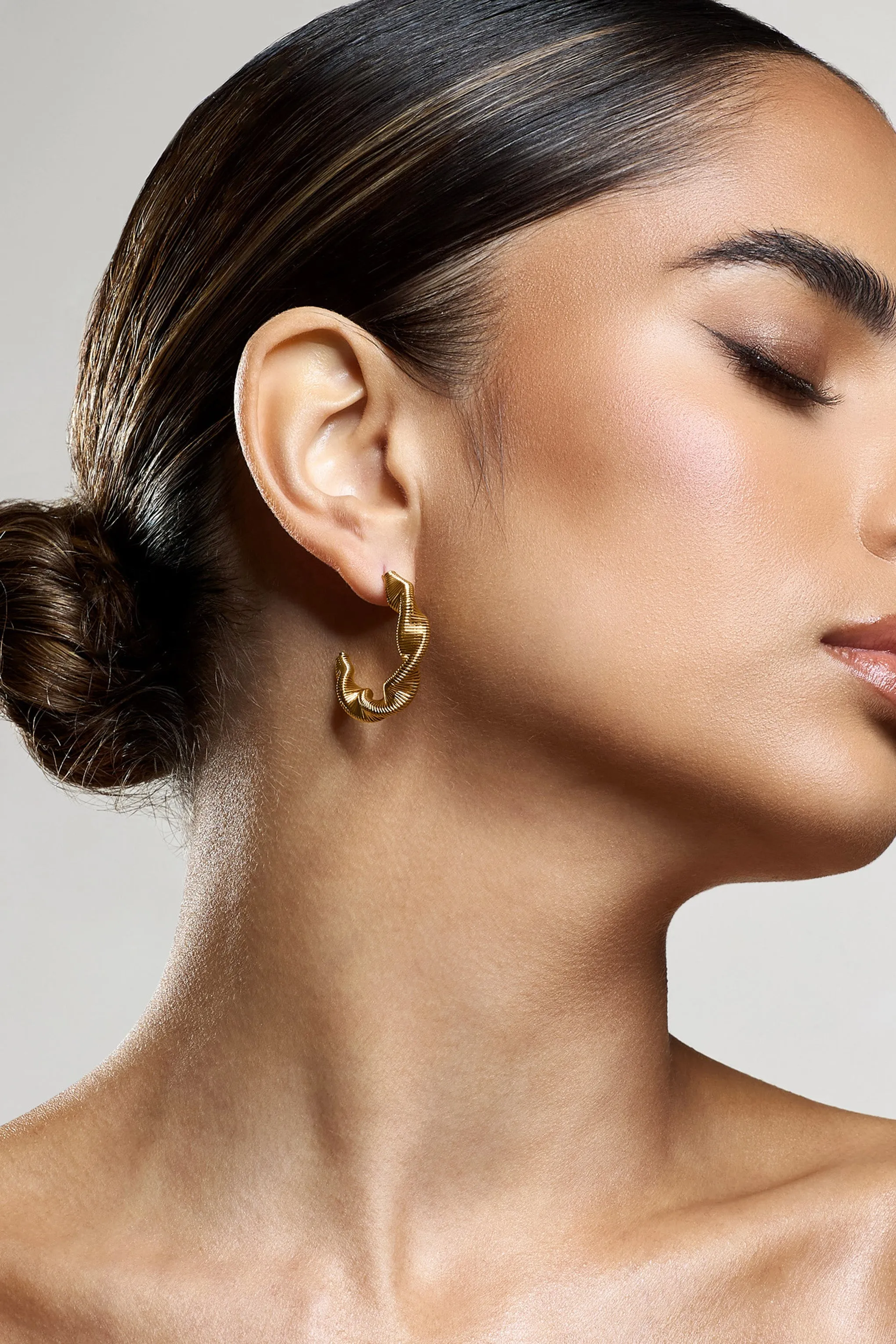 Carli | Gold Twist Hoop Earrings sold by Club L London