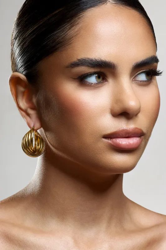 Indigo | Gold Chunky Twisted Hoop Earrings sold by Club L London