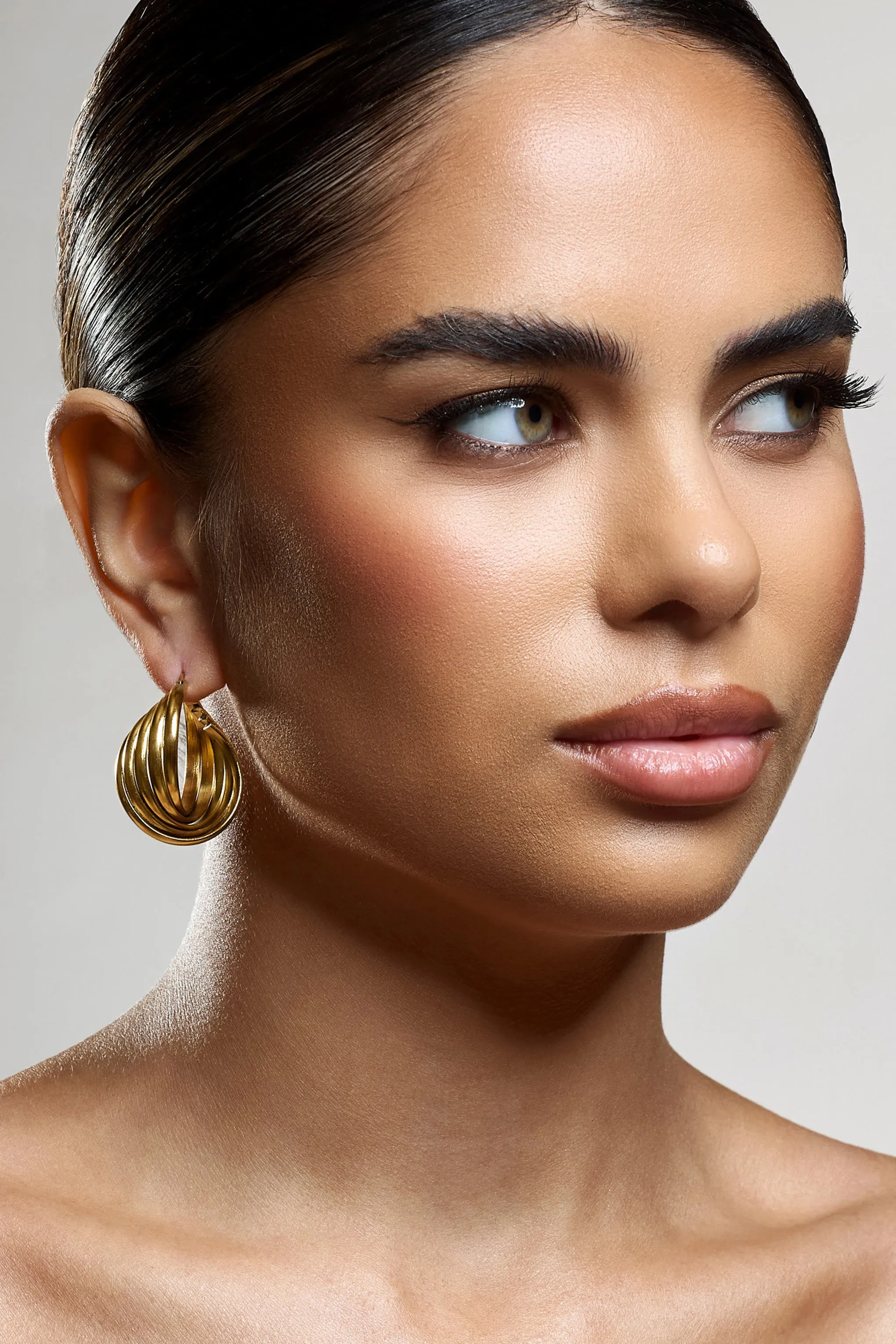 Indigo | Gold Chunky Twisted Hoop Earrings sold by Club L London