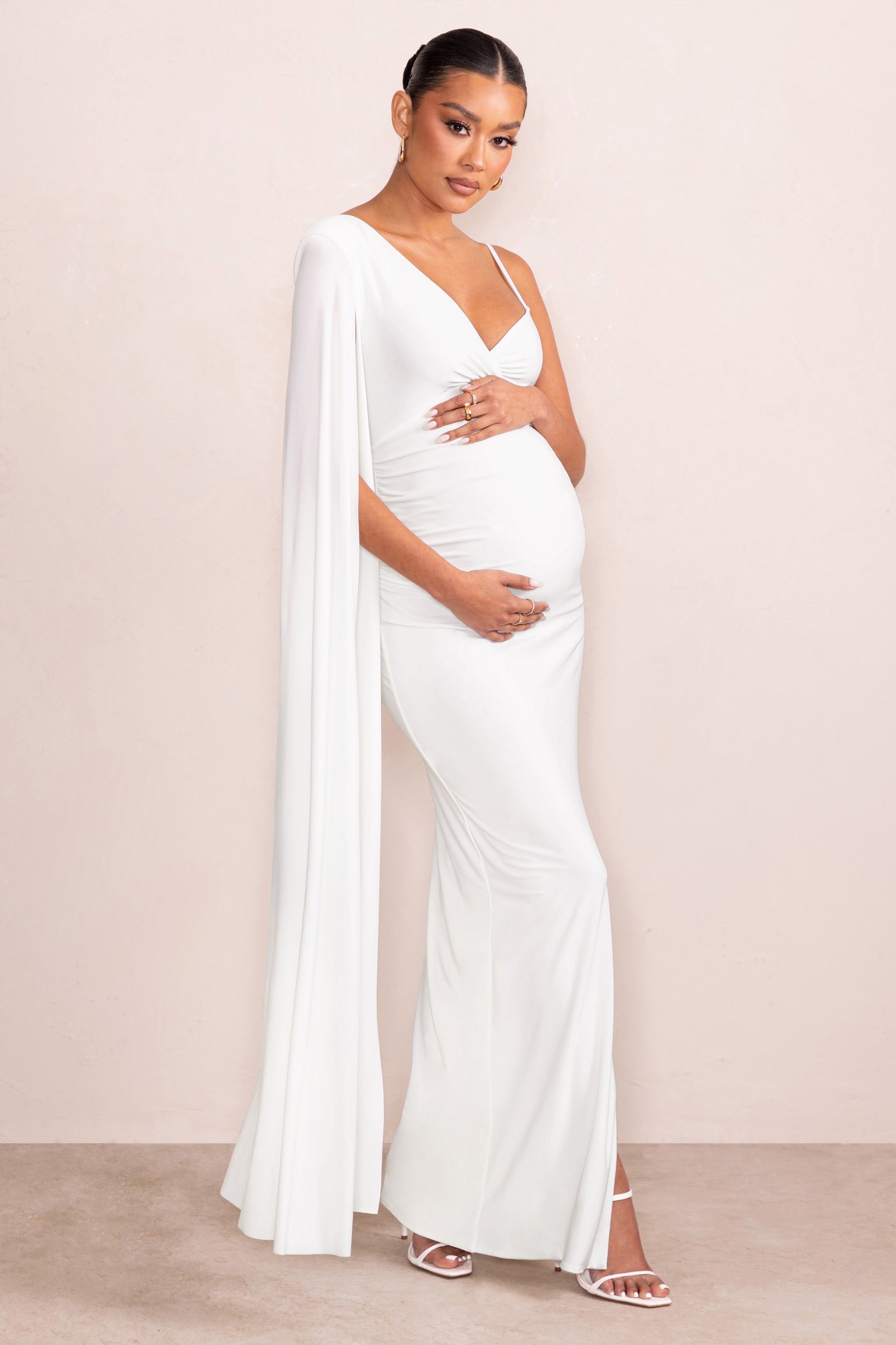 The Crown | White Asymmetric Plunge Maternity Maxi Dress with Cape Sleeve sold by Club L London