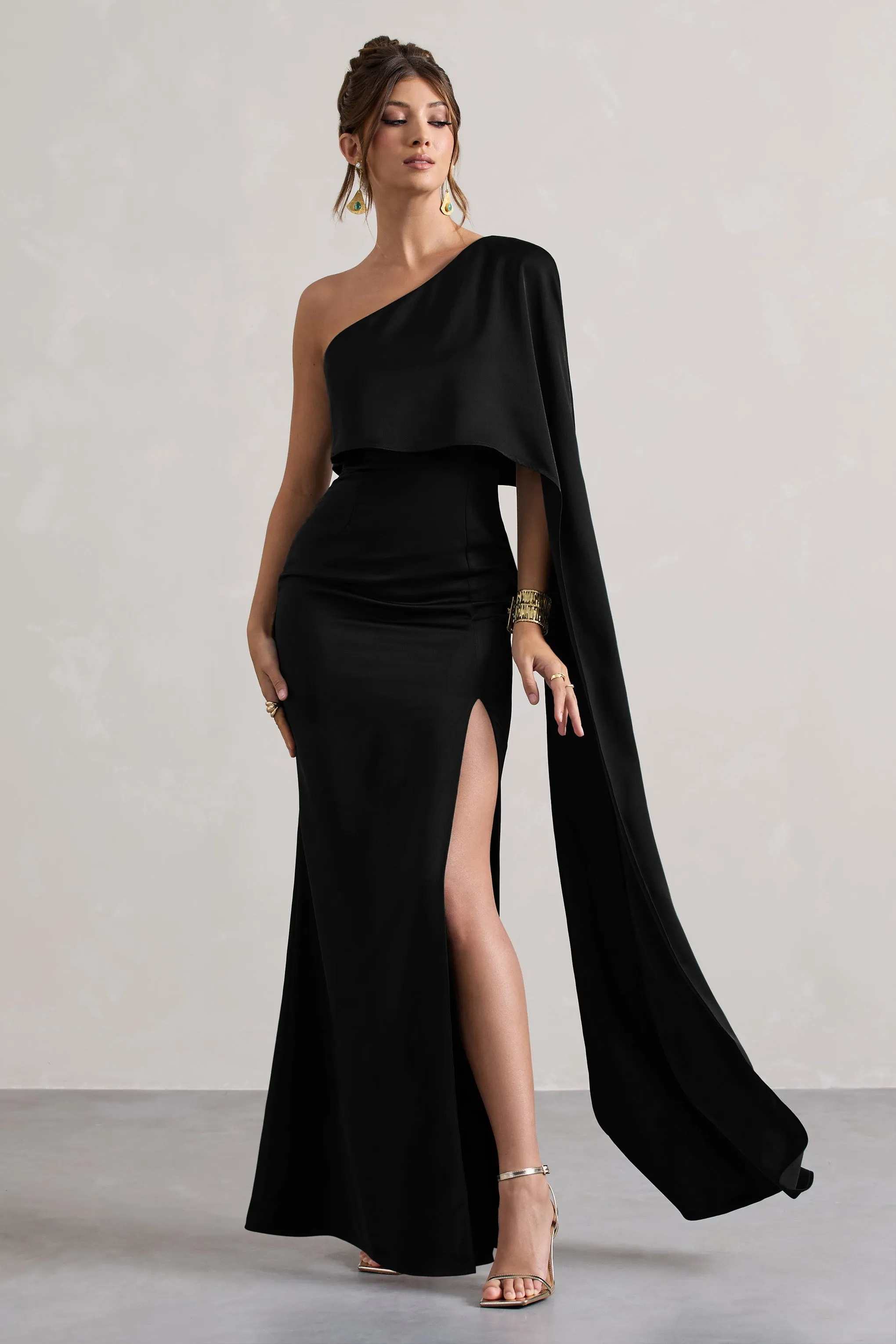 Amora | Black Satin Asymmetric Cape-Sleeve Split Maxi Dress sold by Club L London
