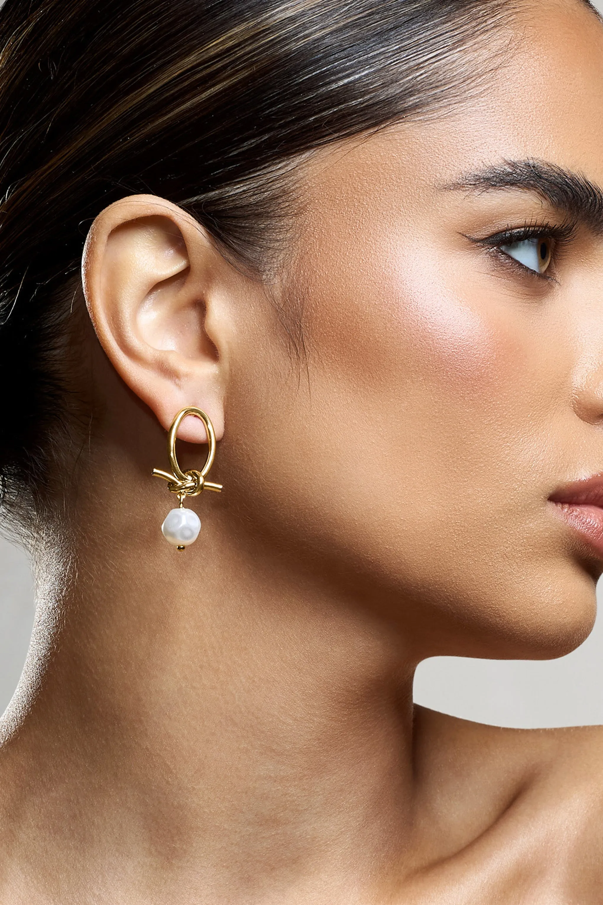 Ivory | Gold Pearl Dangle Earrings sold by Club L London