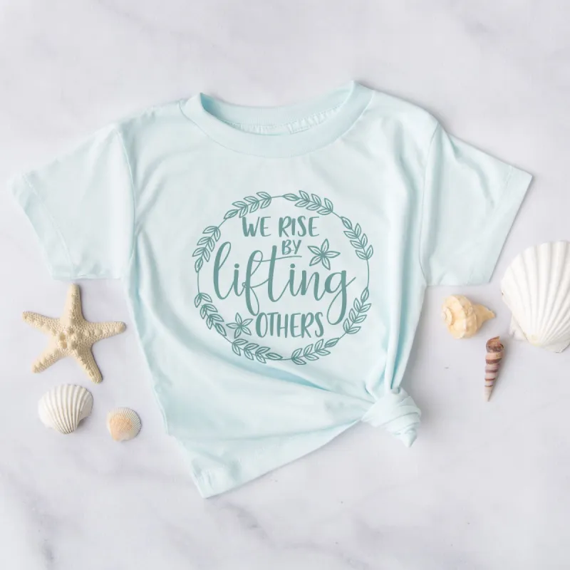 We Rise By Lifting Others - Wreath Tee sold by Faithful and Co.