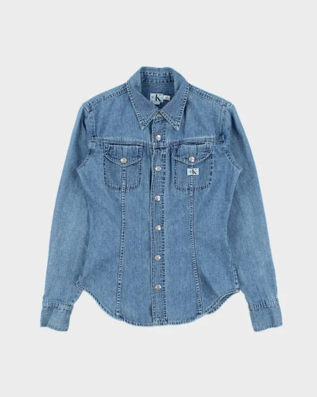 Vintage 1990s Calvin Klein Women's Light Wash Denim Snap Button Long Sleeve Shirt - S made by Calvin Klein