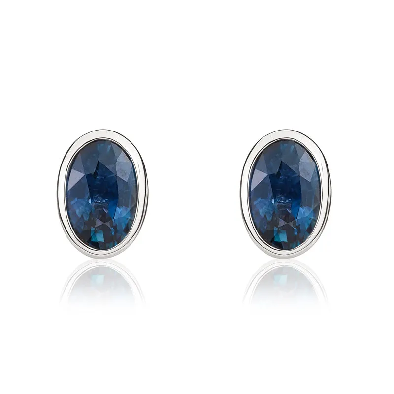 9ct White Gold Sapphire 6x4mm Oval Rub Over Set Stud Earrings sold by Jura Watches