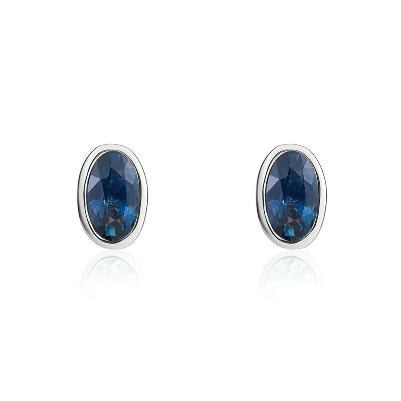 9ct White Gold Sapphire 5x3mm Oval Rub Over Set Stud Earrings sold by Jura Watches