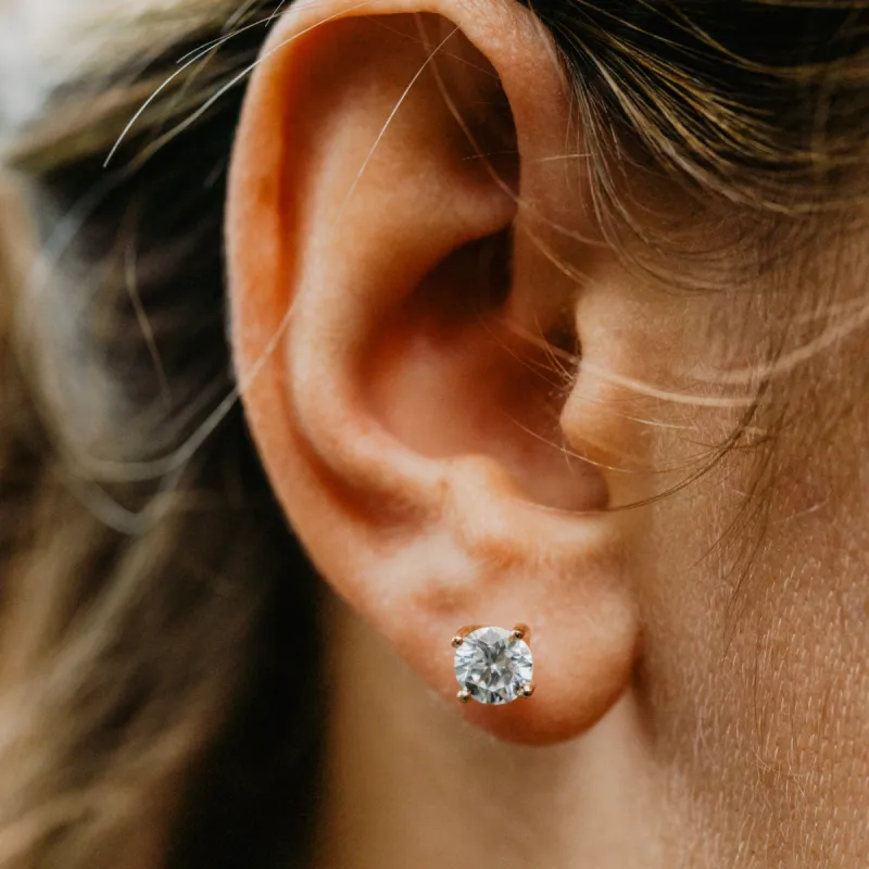 The Aria Earrings | Round Moissanite Twist Four Claw Solitaire Studs sold by Ethica Diamonds