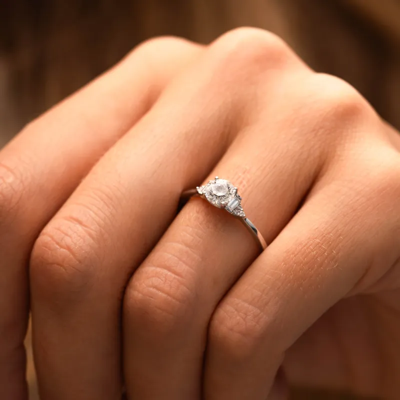 The Abi Ring | Round Moissanite & Diamond Baguette Accented Engagement sold by Ethica Diamonds