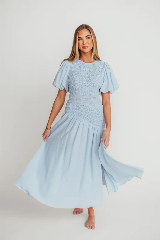 Theoni Asymmetrical Smocked Dress in Blue sold by Worth Collective