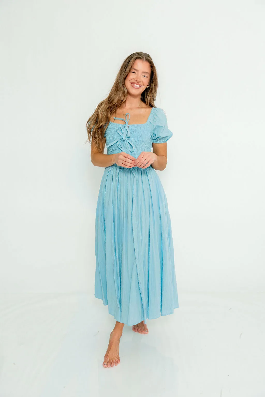 Arabelle Smocked Bow Detail Maxi Dress in Blue Aura sold by Worth Collective