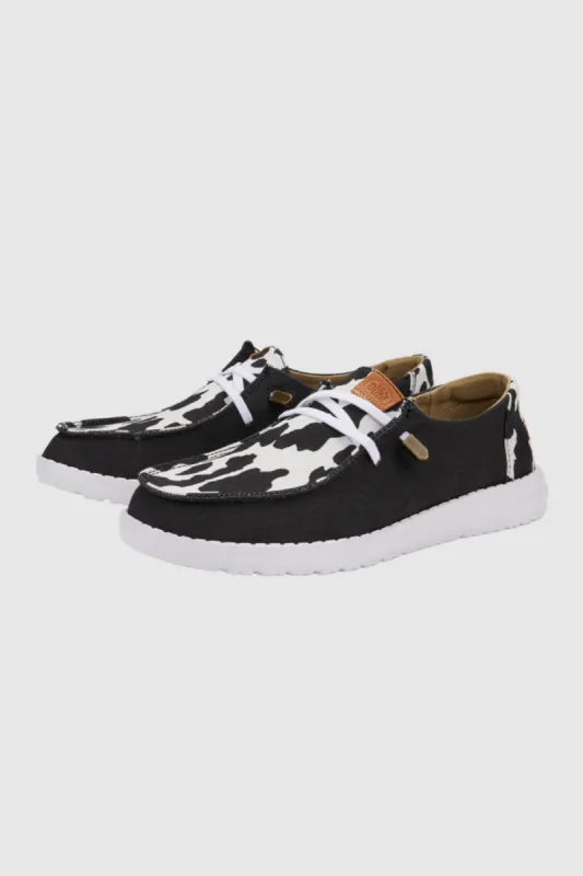 HEYDUDE Women’s Wendy Cow Print Shoes in Black/White | 41037-0HO sold by Glik’s