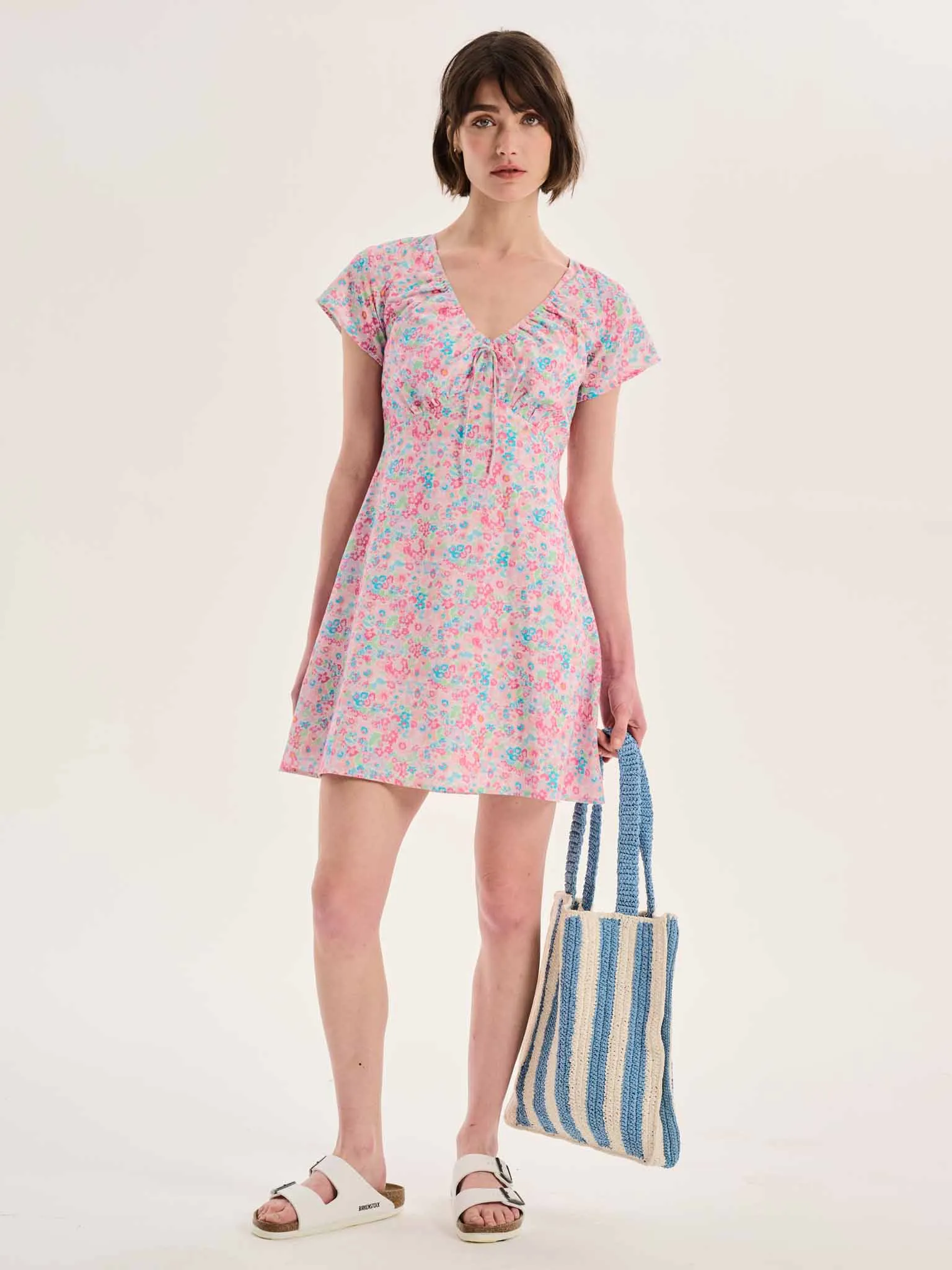 Dotty V Neck Ruched Mini Dress in Floral Print sold by Omnes