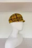 Bubbly black and yellow plaid mod cap (SIZE MEDIUM) sold by Heirloom Hats