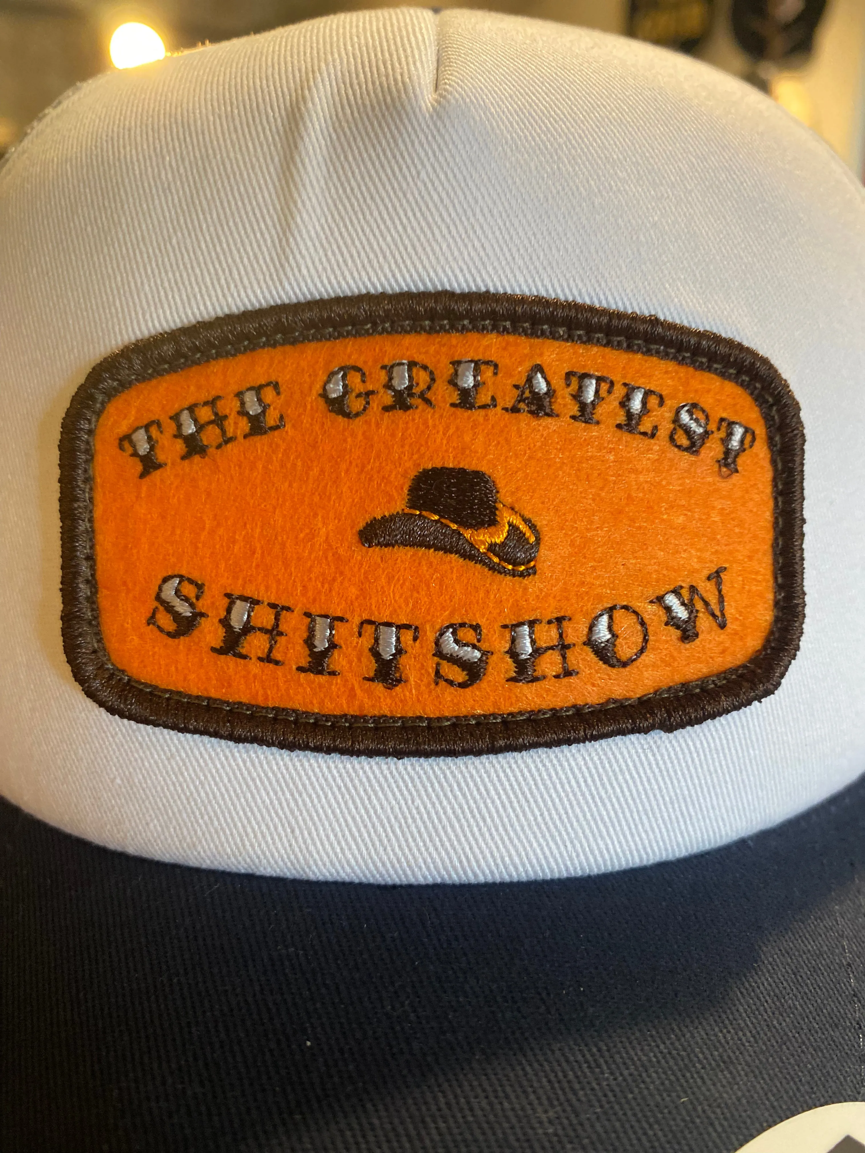 The Greatest $h!t$how - Orange Patch on White/Grey/Navy Trucker sold by Cave and Post product image thumbnail 2