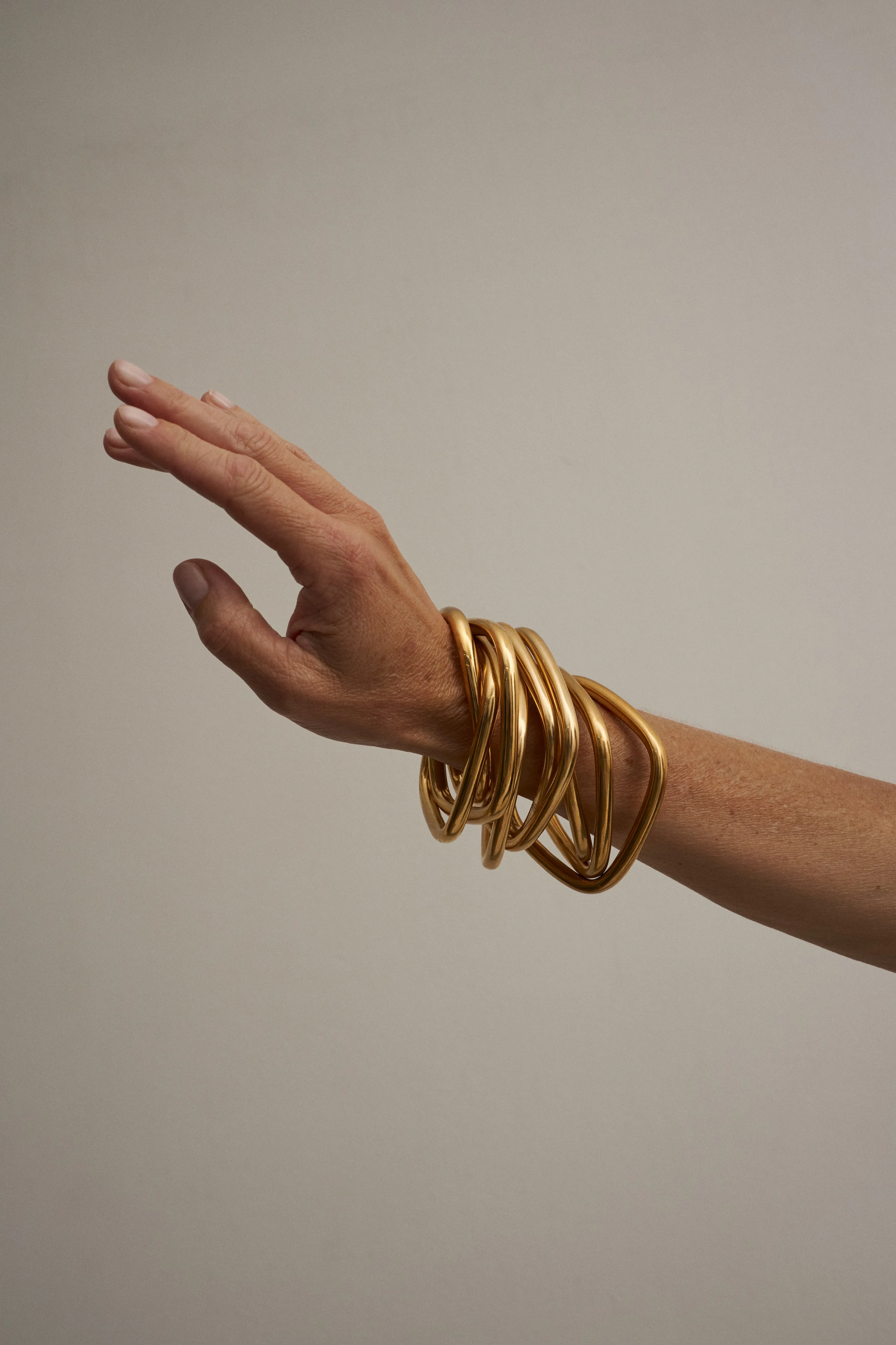 The Interlocking Bangle in Gold sold by Jamie Haller