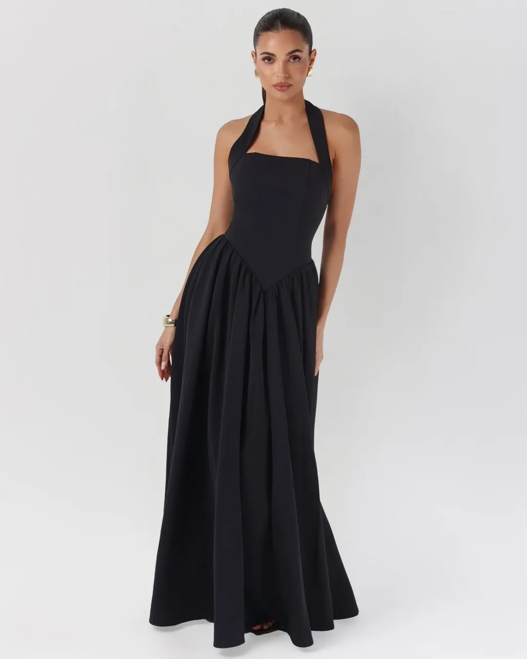 Black halter contour flowy maxi dress sold by Heiress Beverly Hills