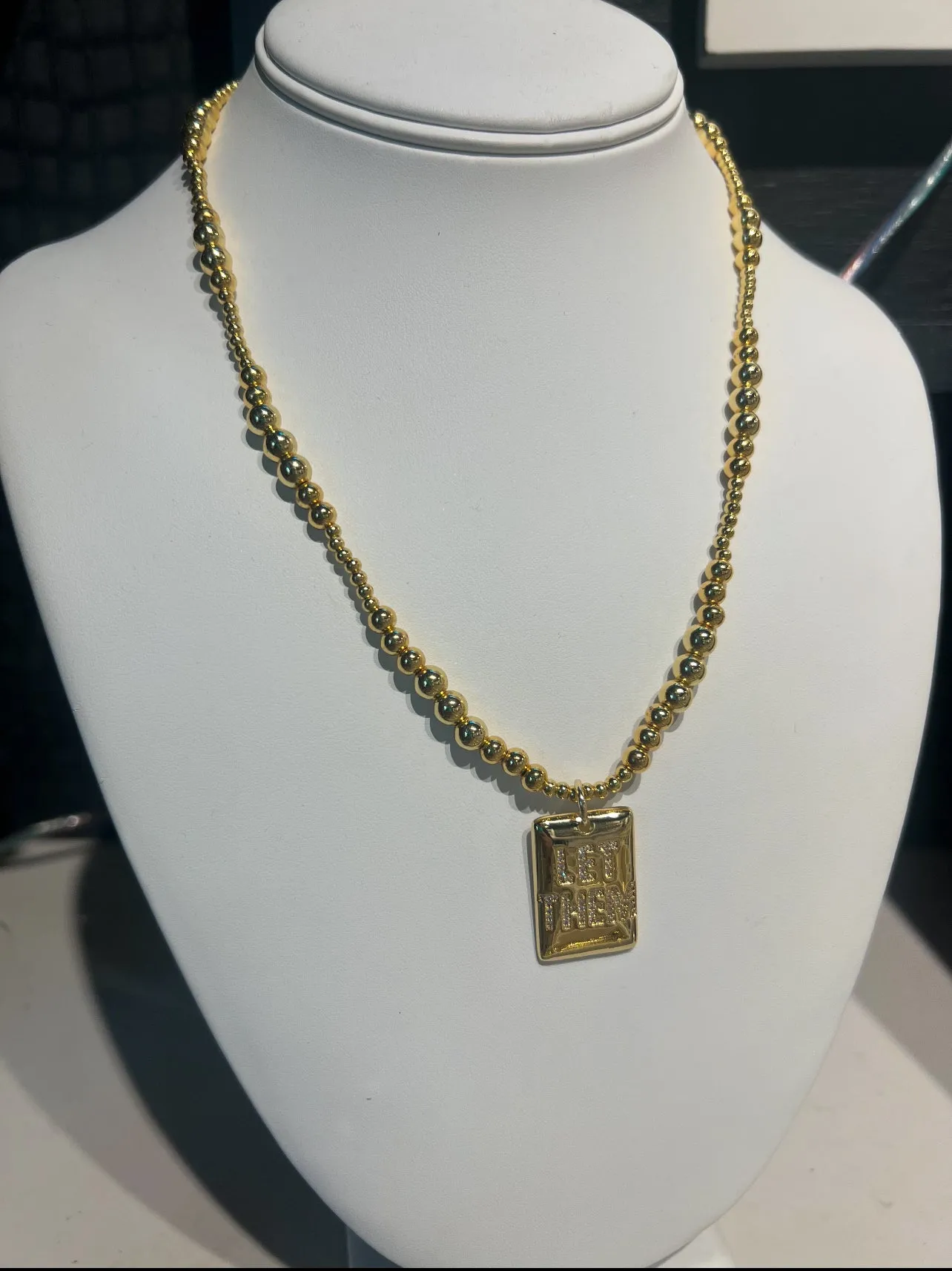 LET THEM gold beaded necklace sold by Care Tucker