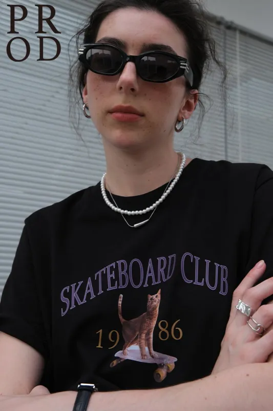 1986 Skateboard Club - Cat Graphic Basic Short Sleeve T-Shirt / Black sold by PROD Bldg