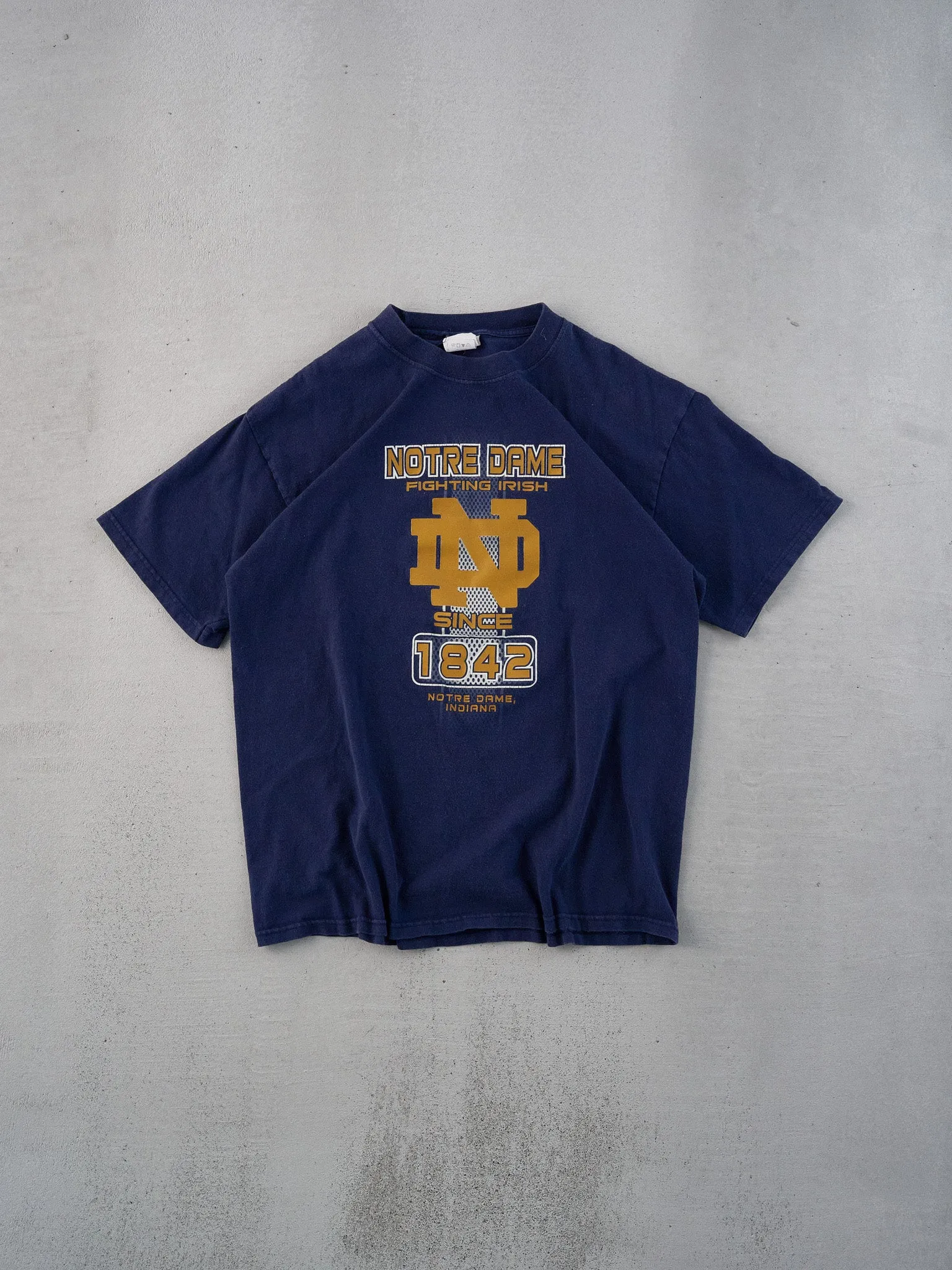 Vintage 90s Navy Blue Notre Dame Fighting Irish Graphic Tee (M) sold by Rebalance Vintage