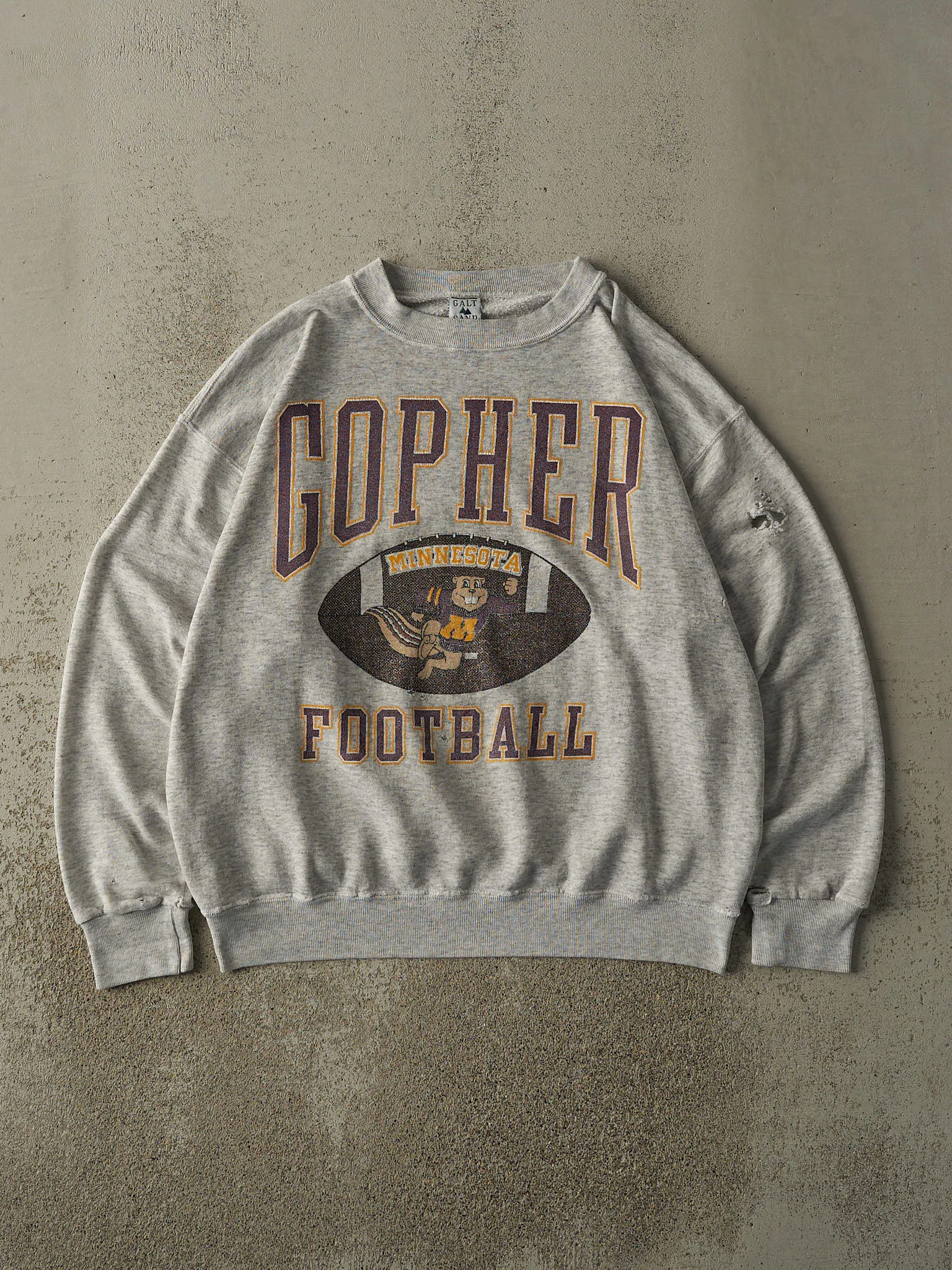 Vintage 90s Heather Grey University of Minnesota Gopher Football Crewneck (L/XL) sold by Rebalance Vintage