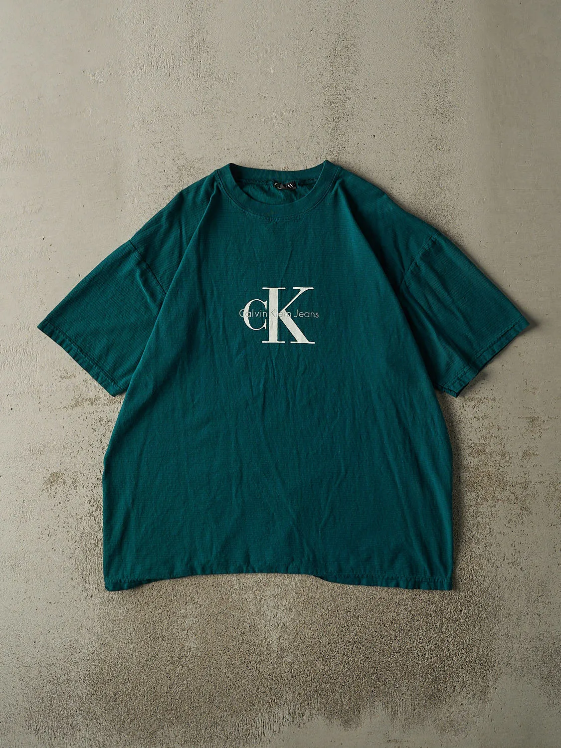 Vintage 90s Teal Calvin Klein Jeans Tee (XL/XXL) sold by Rebalance Vintage