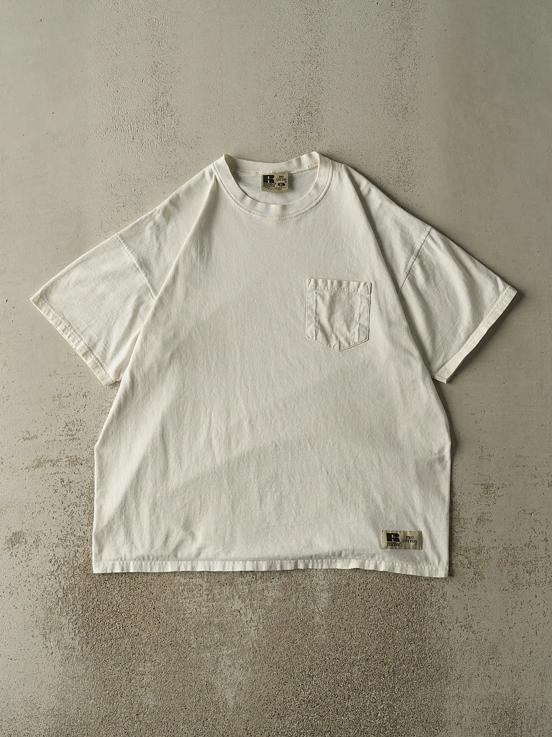 Vintage 90s White Russell Athletic Blank Pocket Tee (XL) sold by Rebalance Vintage