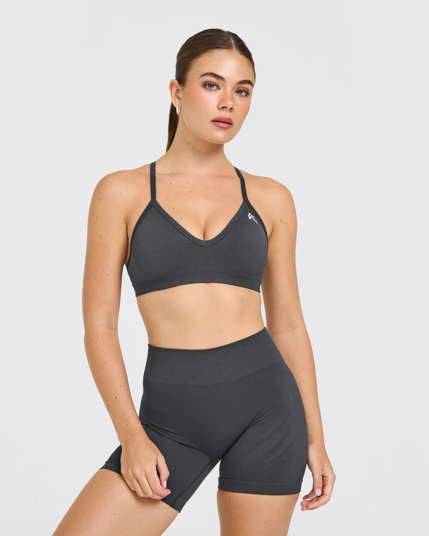 EnhanceLift™ Seamless Strappy Sports Bra with White Logo | Coal sold by Oner Active
