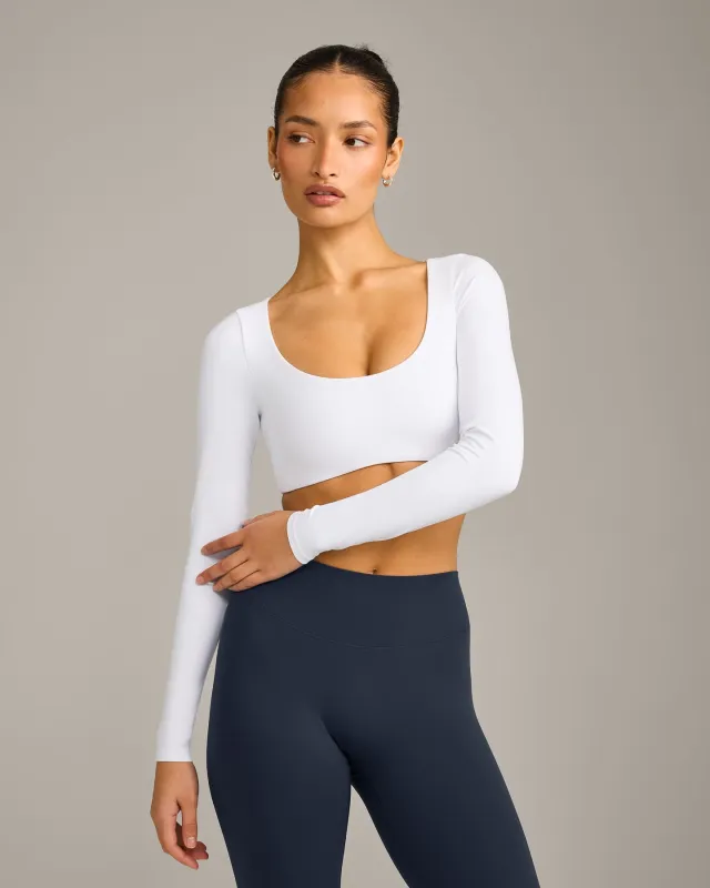 SoftMotion™ Scoop Neck Long Sleeve Crop Top with Built in Bra Shelf with Grey Logo | White sold by Oner Active