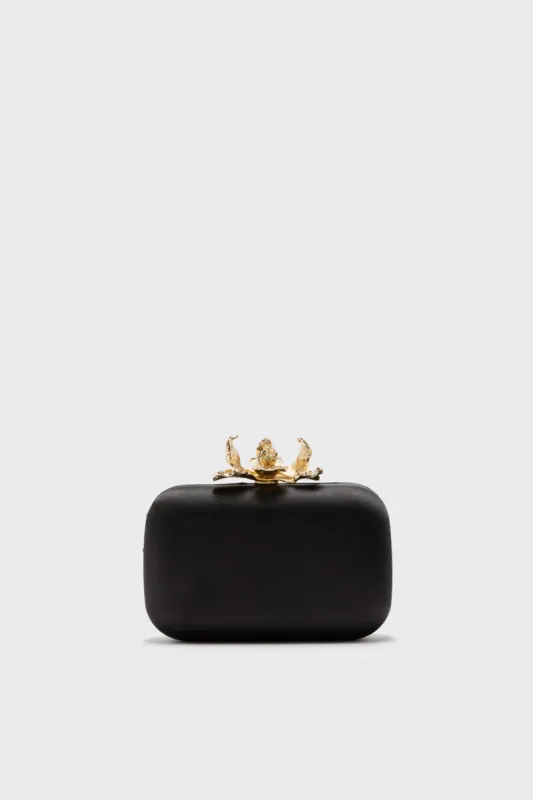 Black Adele Orchid Lock Clutch sold by Tuckernuck