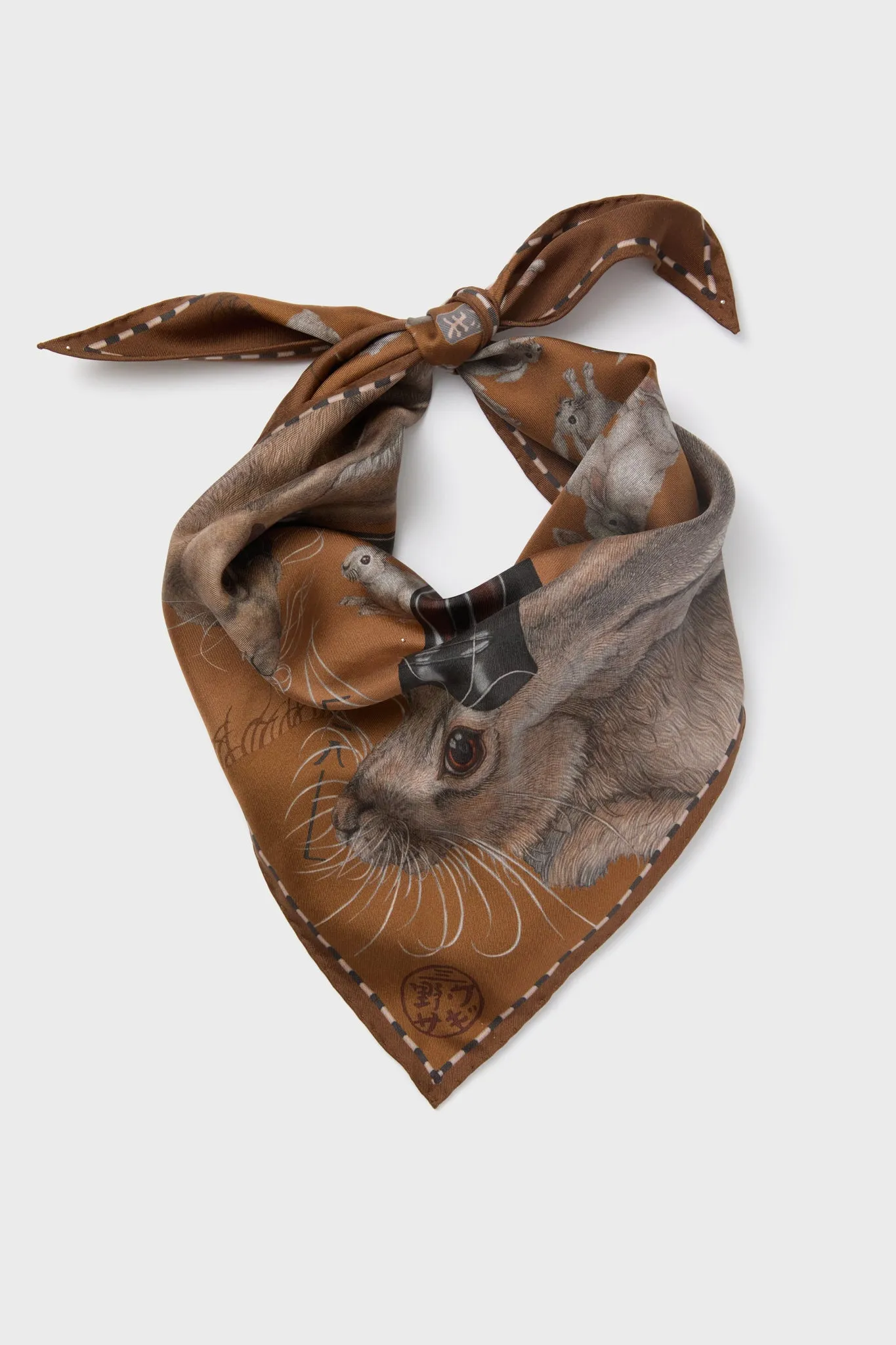 The Floating Rabbits Cinnamon Triangle Scarf sold by Tuckernuck