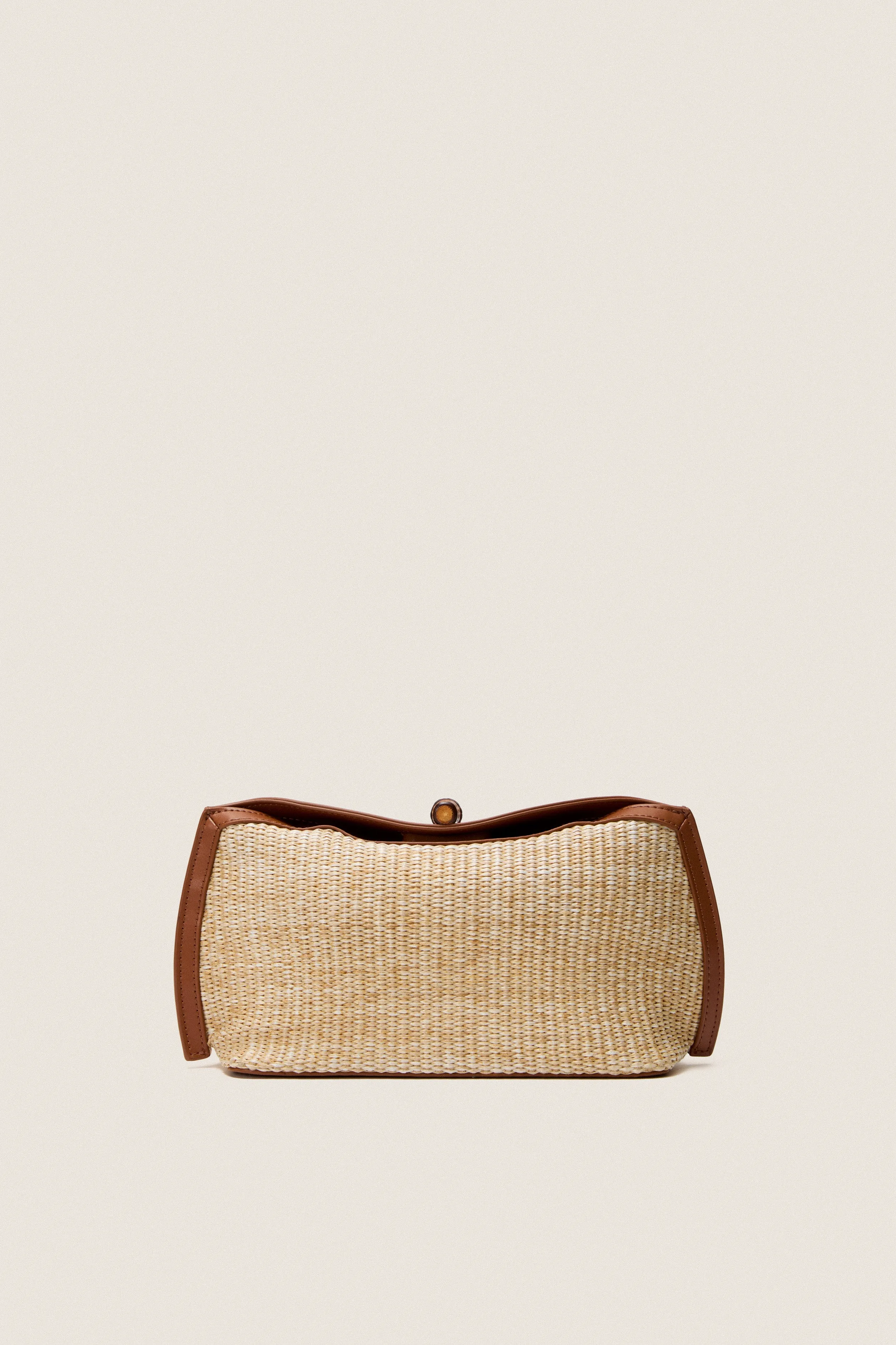 Cognac and Raffia Lock Clutch sold by Tuckernuck