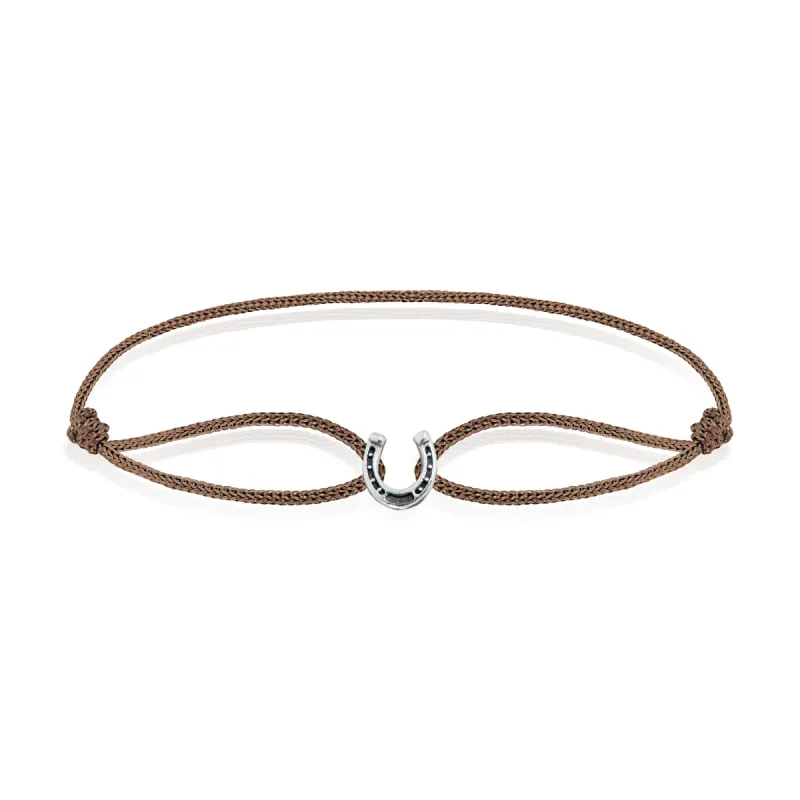 The Epona Horseshoe Bracelet Sterling Silver Tan Cord sold by The Jewelry Edit