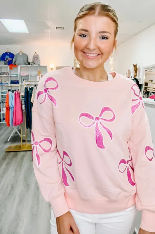 pink sequin bow sweater sold by Roxie’s Picks