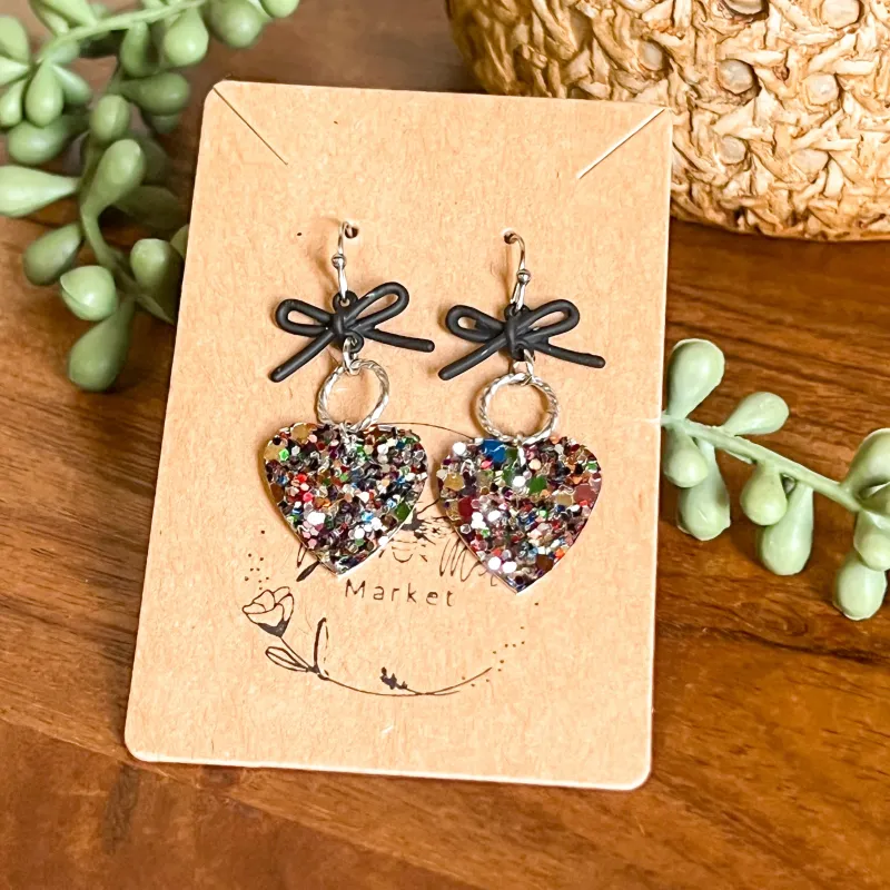 Cara Glitter Heart & Black Bow Earrings sold by Roxie’s Picks