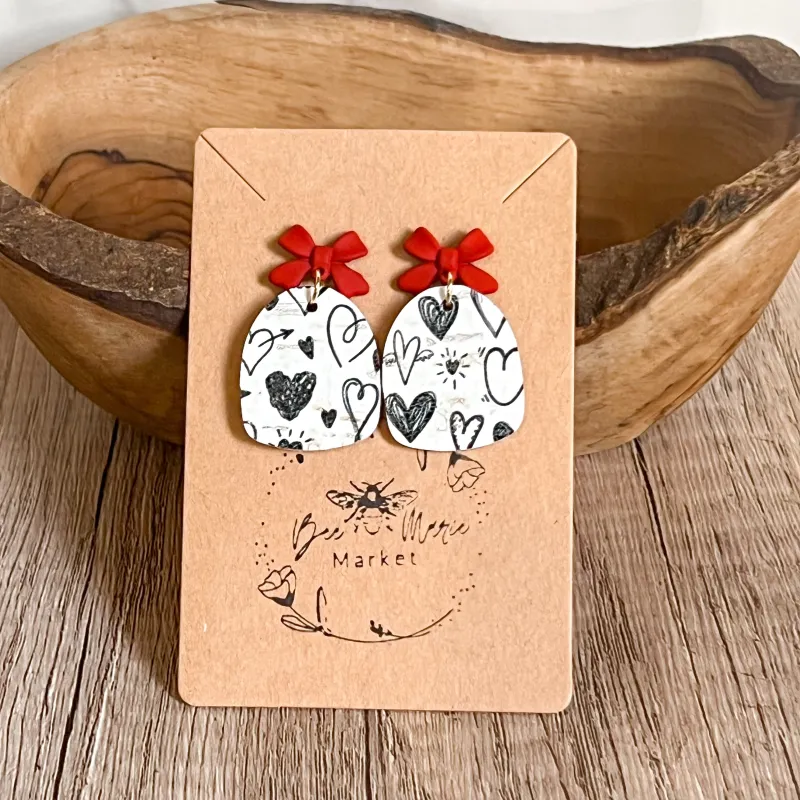 Jessie Black & White Heart Arch Bow Earrings sold by Roxie’s Picks